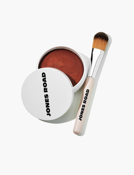The Skin Brush by Jones Road Beauty being shown next to Miracle Balm in shade Tawny