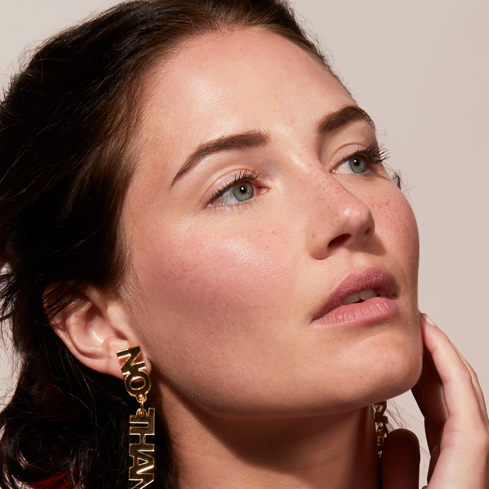 A woman wearing Jones Road Beauty's Lip and Cheek Stick in Bright Pink